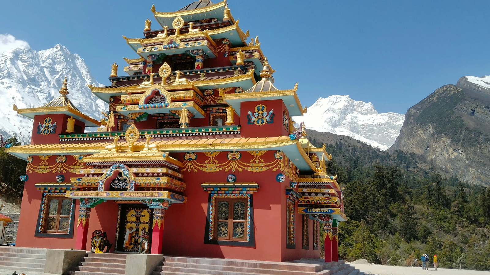 Buddhist monastery along the Manaslu Circuit Trek route in Nepal, featuring traditional stone architecture, prayer flags, and a Himalayan mountain backdrop in a serene high-altitude landscape.