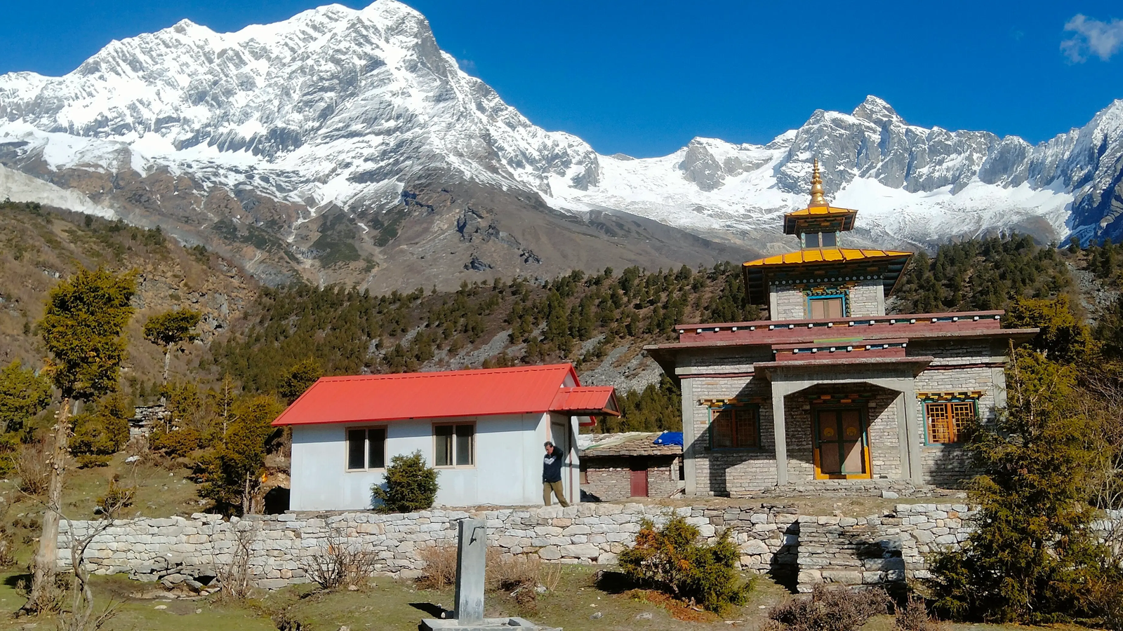 Buddhist monastery in Samagaon along the Manaslu Circuit Trek route, surrounded by majestic mountains, an alpine valley, and traditional Himalayan village scenery.