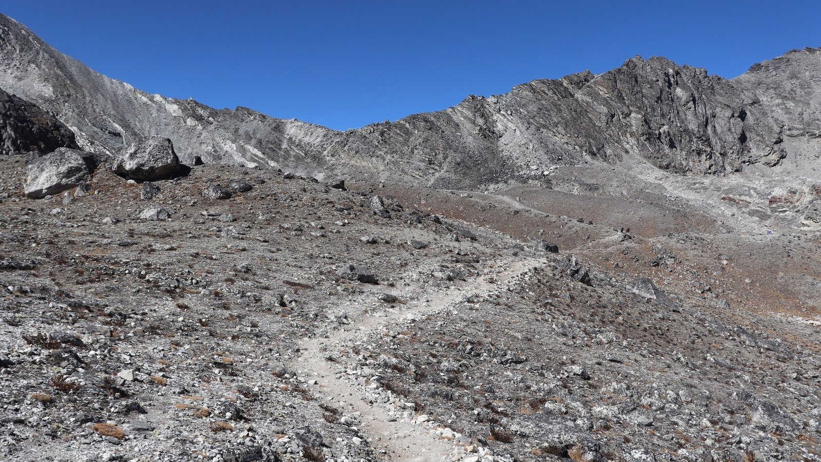 Trekkers crossing the rugged Everest High Pass trail near Kongma La Pass top with snow-covered Himalayan peaks