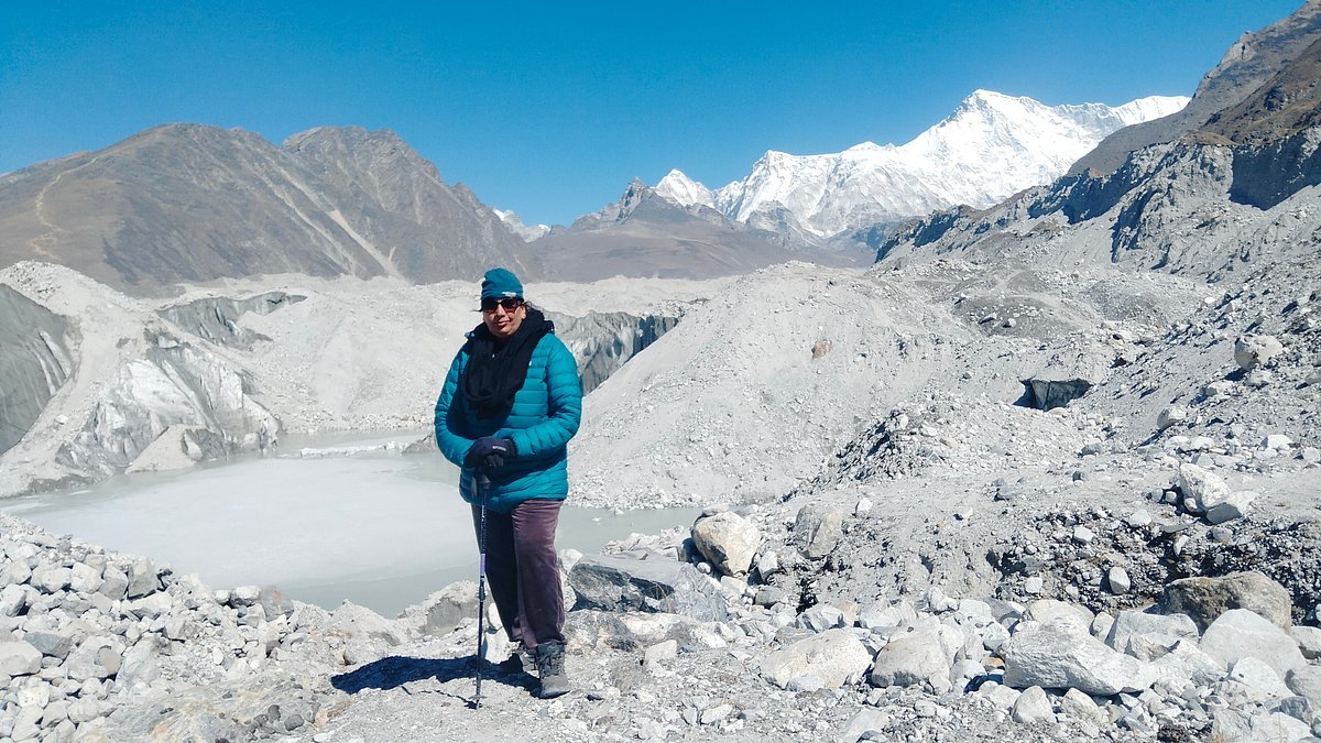 Everest Three Pass Trek – Trekker standing on rocky Himalayan trail with snow-capped mountains, glaciers, and alpine scenery in the Everest region of Nepal.