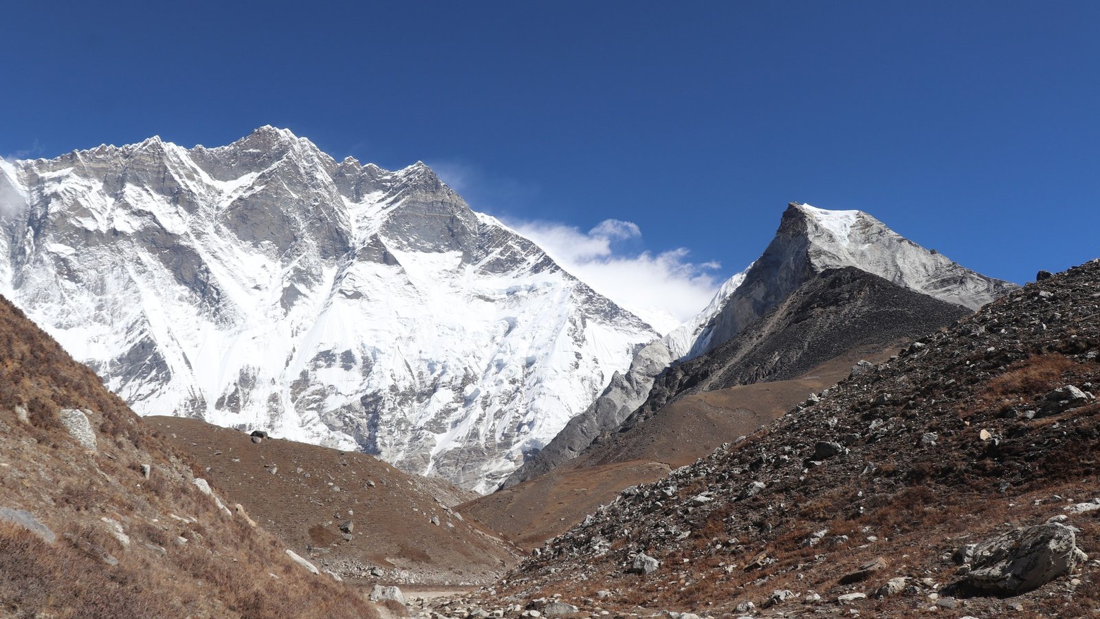 Climbers ascending the steep snowy ridge on Island Peak climbing route with ropes and panoramic Himalayan peaks