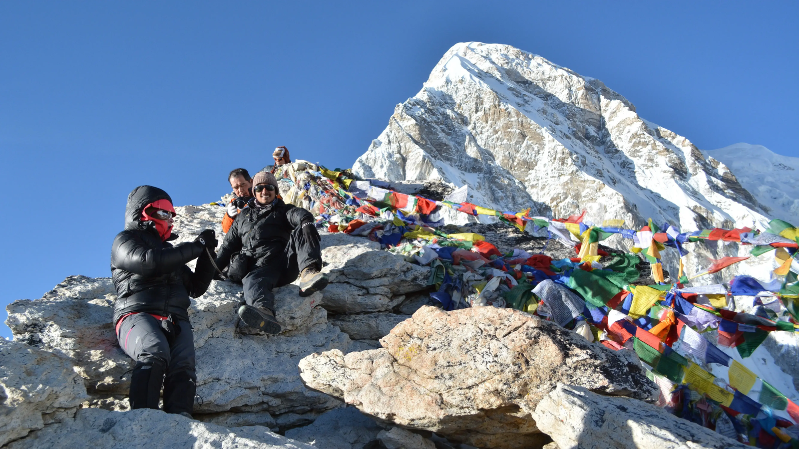 Everest Base Camp trek view from Kala Patthar, showing trekkers on the trail and towering Himalayan peaks behind.