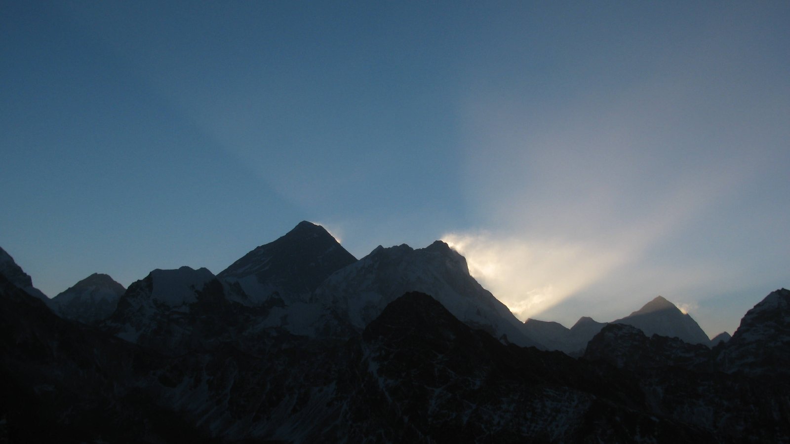 Mount Everest morning view from the top of Gokyo Ri with glowing Himalayan peaks and clear blue sky.