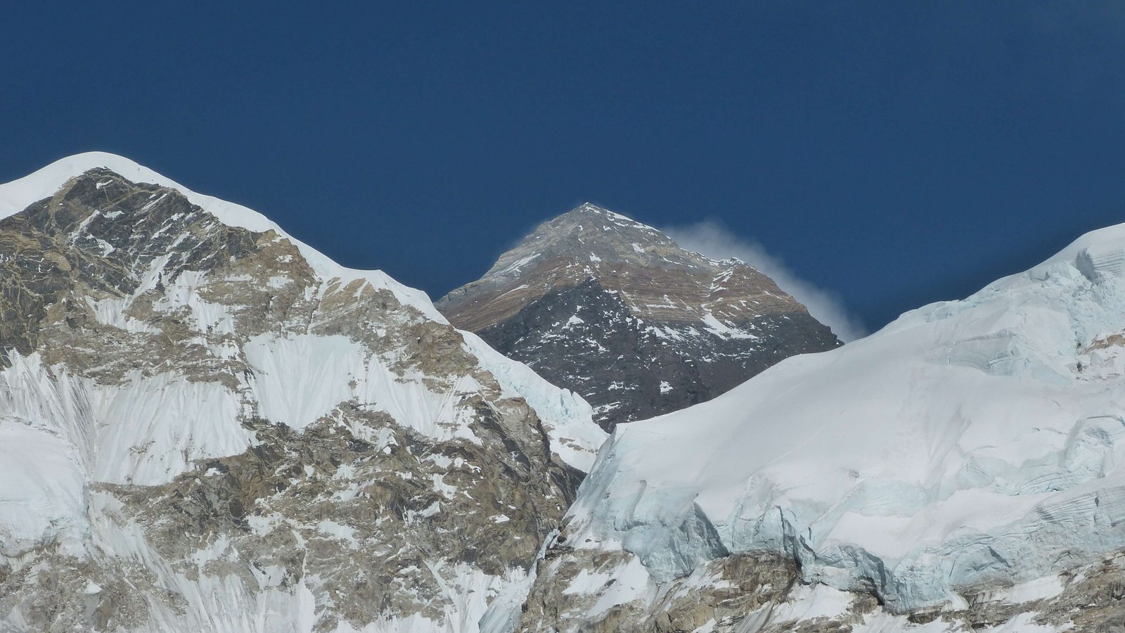 Majestic view of Mount Everest towering above the Himalayas under a clear blue sky.