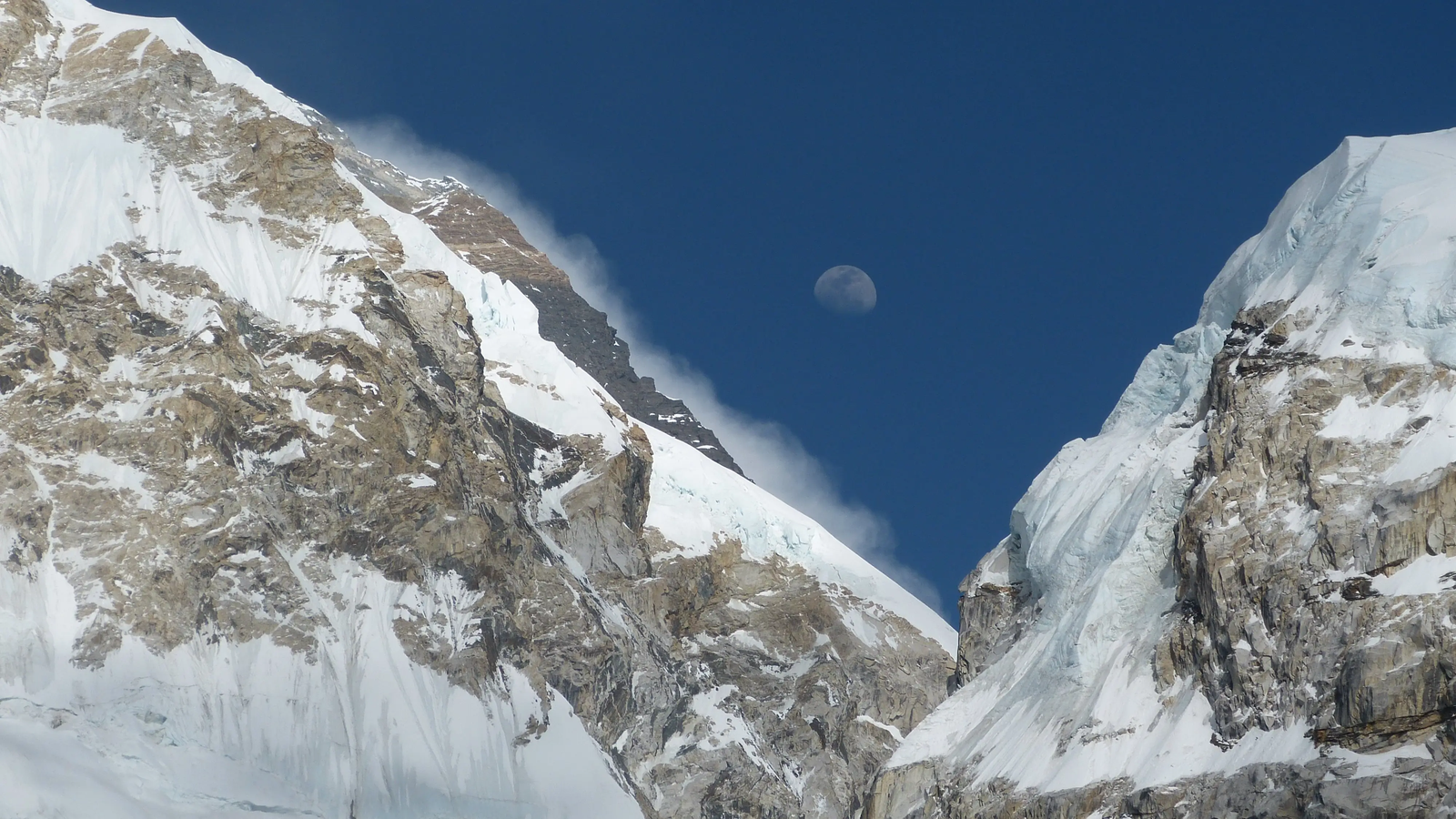 Moon rising behind Mount Everest summit, glowing over the Himalayas.