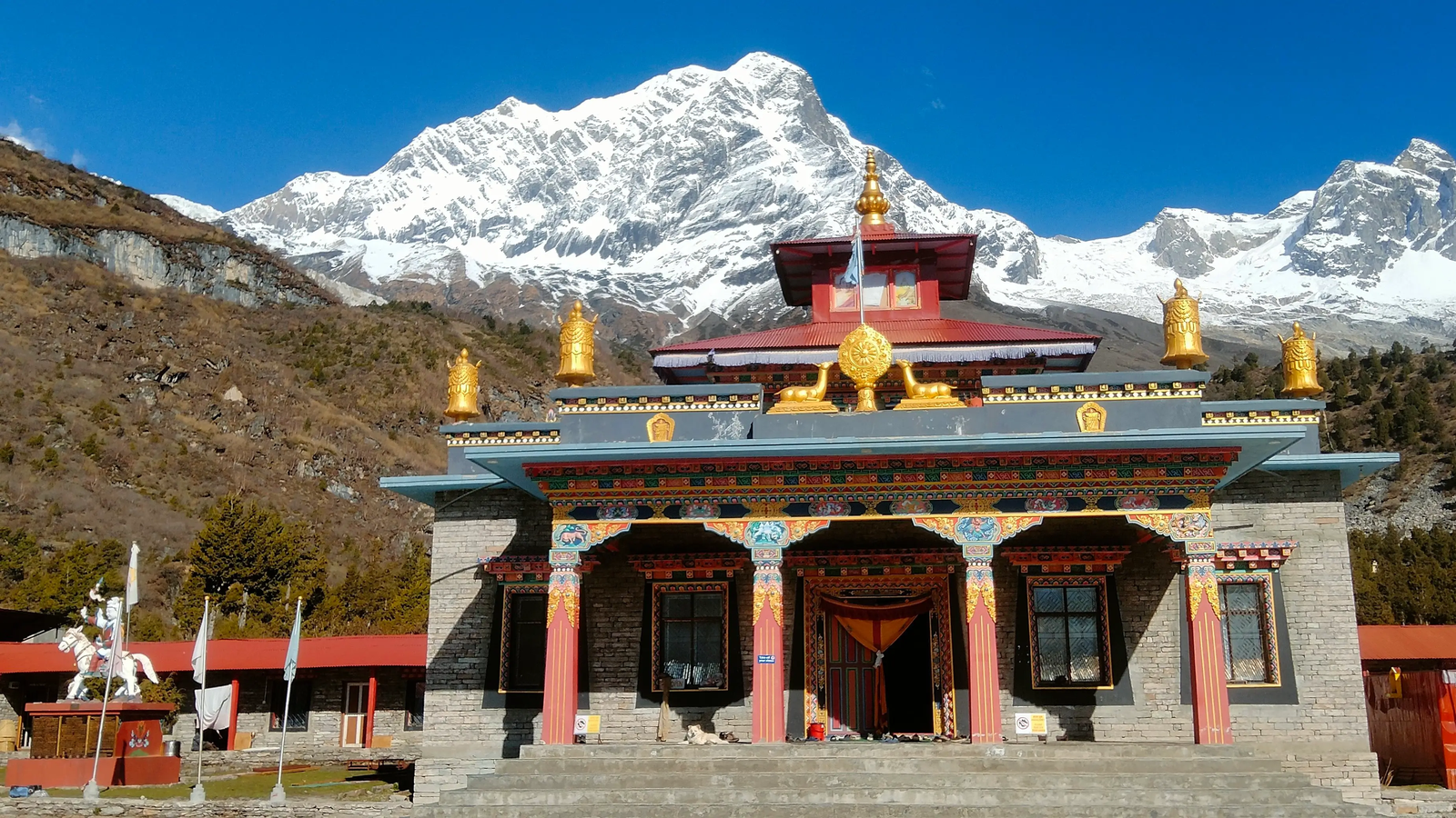 Samagaon village monastery with Tibetan culture, colorful prayer flags, and dramatic Himalayan landscape on the Manaslu trekking route.