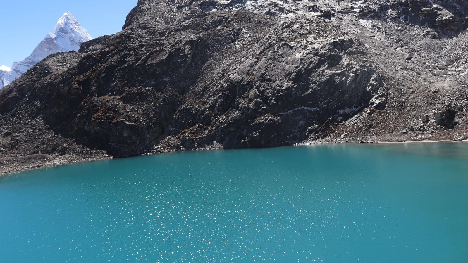 Scenic alpine lake on the Everest High Pass Trek surrounded by rocky terrain and high Himalayan mountains