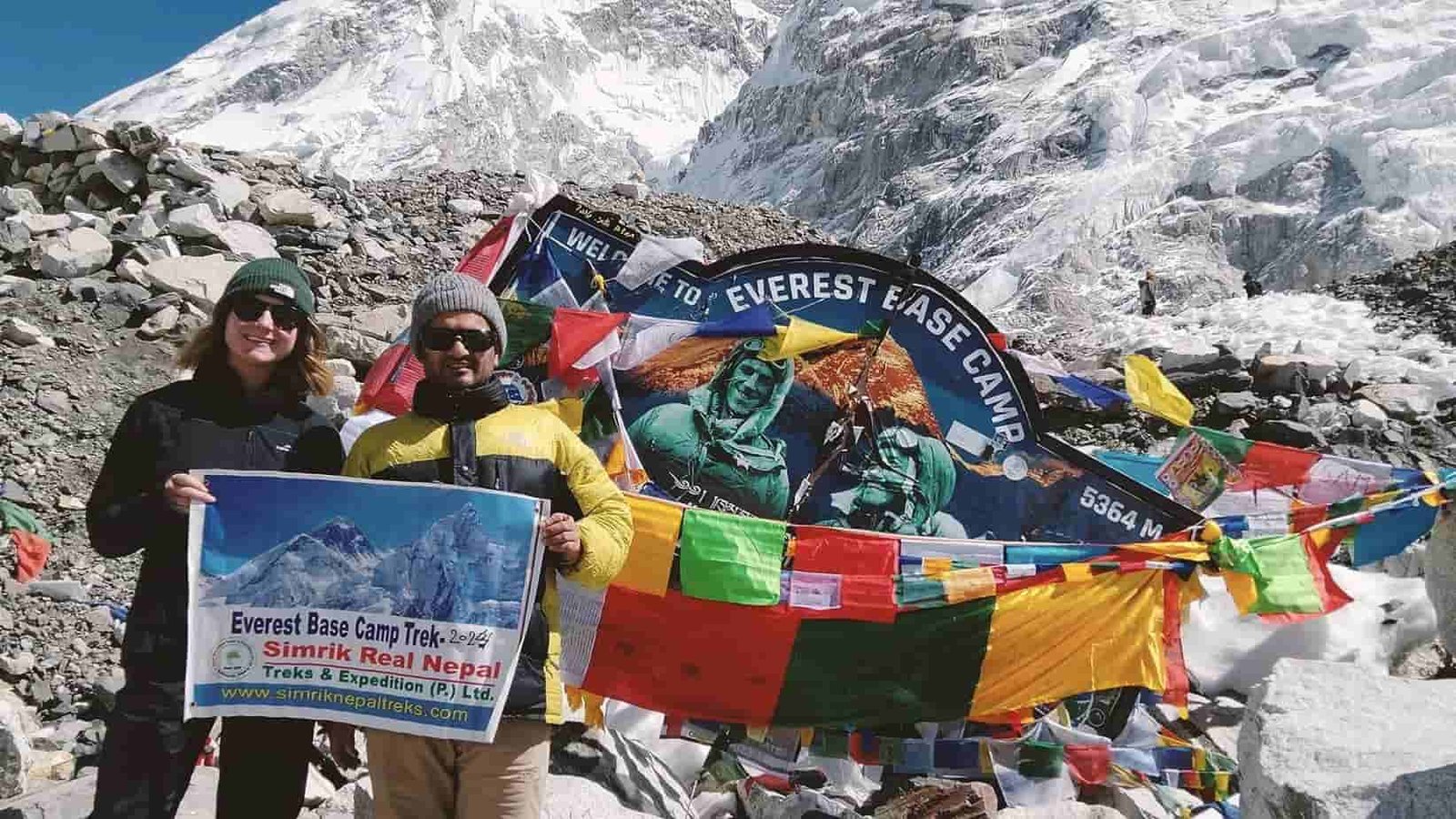 Trekker stands at Everest Base Camp with Khumbu Icefall view