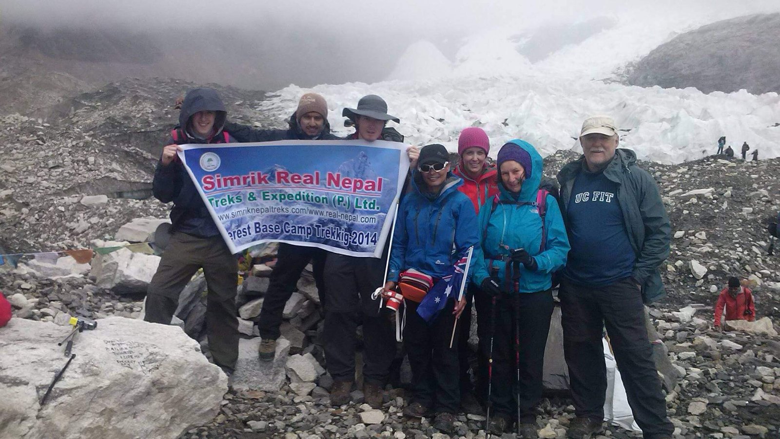 Trekkers holding Simrik Real Nepal banner at Everest Base Camp – Himalayan adventure, trekking team, and Khumbu region experience in Nepa