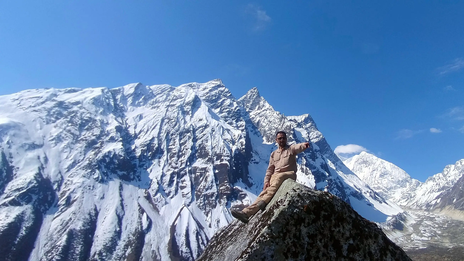 Trekkers pointing at Himalayan peaks on the Manaslu Circuit Trek route from Samdo to Dharamsala, along a rugged high-altitude trail with snow-capped mountain scenery in Nepal.